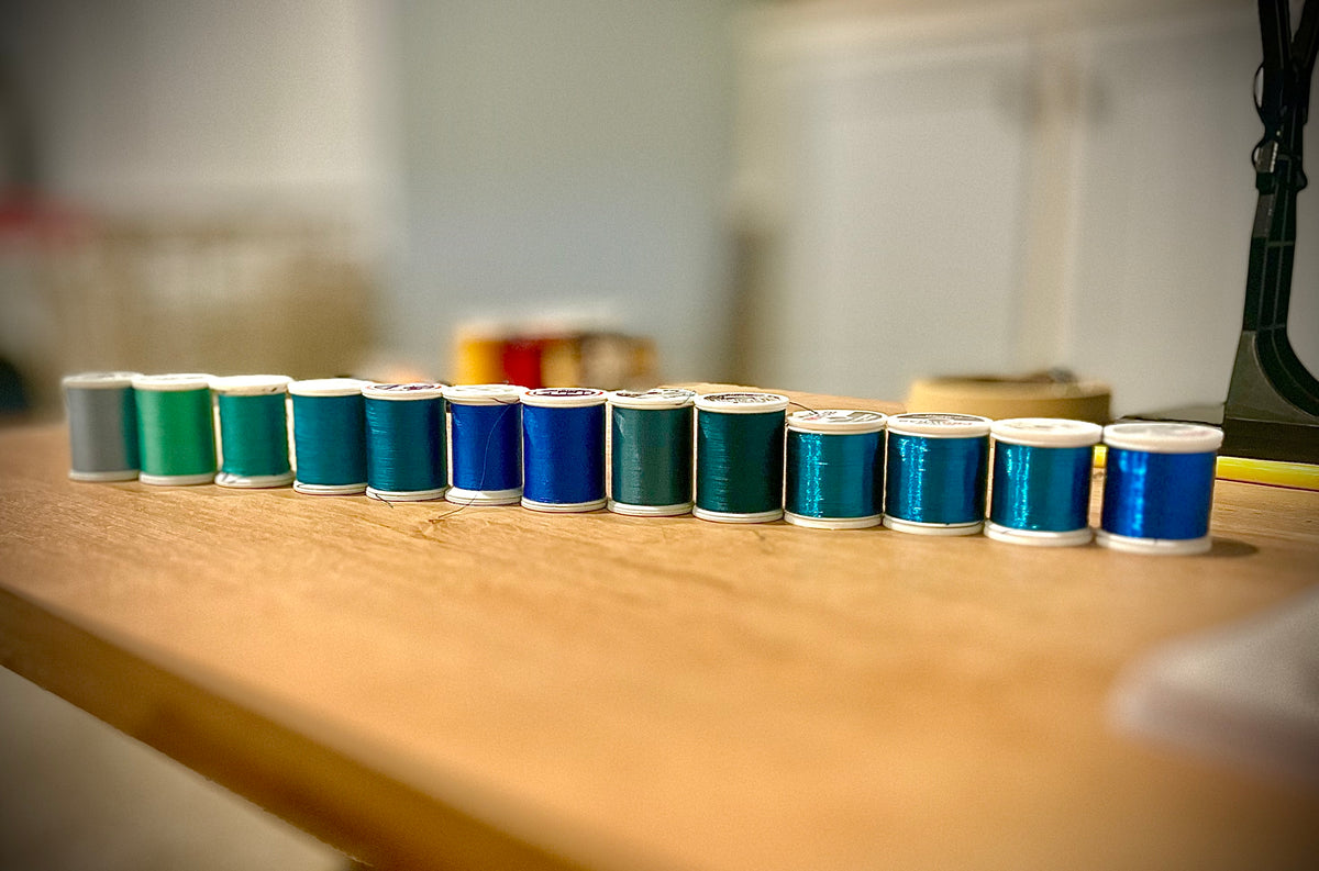 line up of different colored thread spools